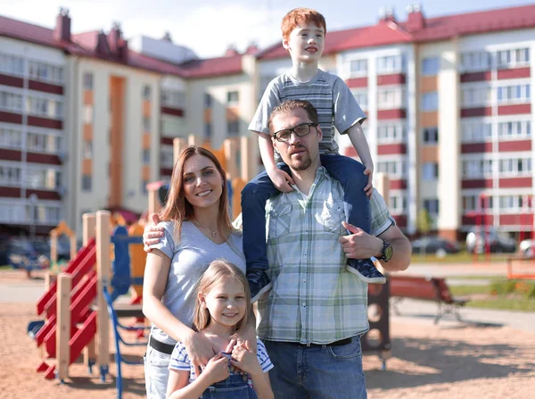 young family standing in the yard of a new residential building