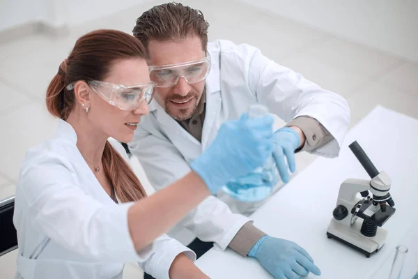 Two chemists working with different liquids in tubes — Stock Photo, Image