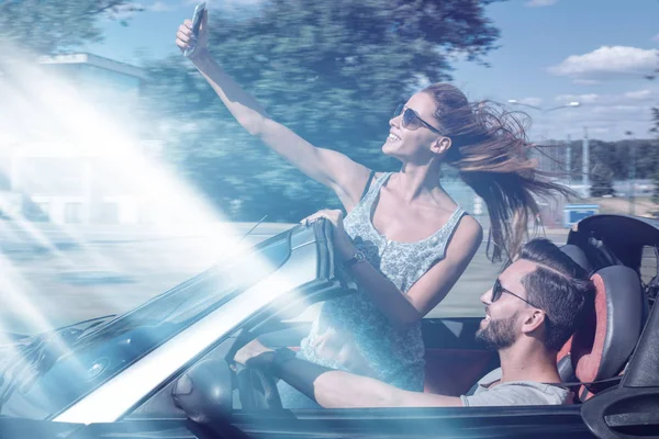 Encantador jovem casal tomando selfie no carro — Fotografia de Stock