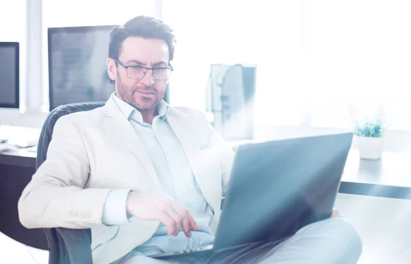 Affärsman som använder en bärbar dator sitter vid sitt skrivbord — Stockfoto