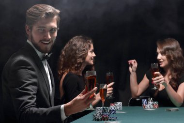 Başarılı bir poker oyununu kutlayan mutlu bir grup insan.