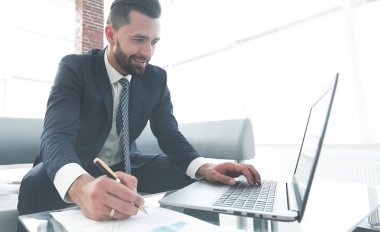 Dizüstü bilgisayarda çalışan ve Notlar not defterinde yapma şık adam