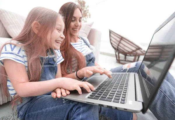 Gelukkig moeder met schattig meisje met laptop — Stockfoto