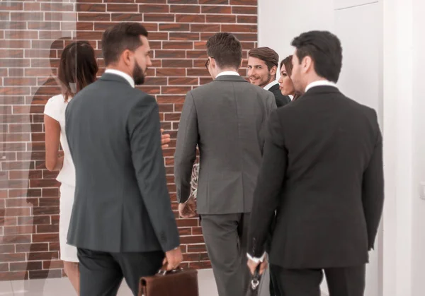 Gruppo di uomini d'affari che parlano, in piedi nella hall del business center . — Foto Stock
