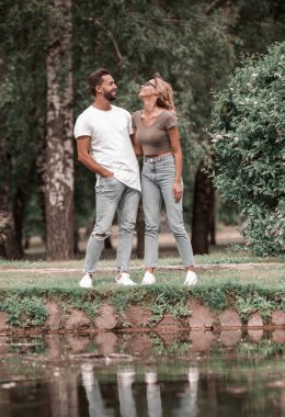 Çift ayakta lake Park yakınındaki çimenlerin üzerinde sevgi dolu