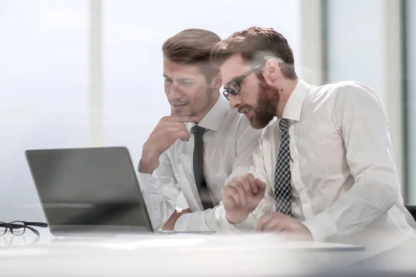 Два бизнес-коллеги обсуждают информацию, сидя за столом — стоковое фото