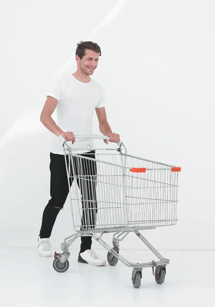 Uomo sorridente spingendo carrello della spesa . — Foto Stock