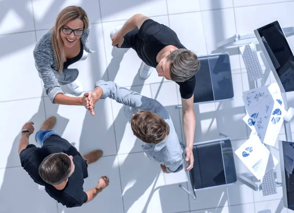 Jóvenes en la oficina se dan una mano — Foto de Stock