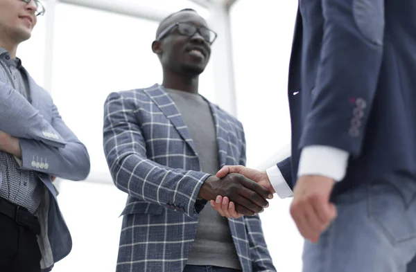 Взгляд снизу. Молодой бизнесмен пожимает руку своему деловому партнеру — стоковое фото