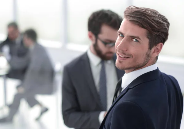 Young businessman standing in a modern office — Stock Photo, Image