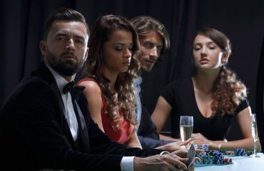 Kumarhanede poker oynayan bir grup insanın yan görünüşü