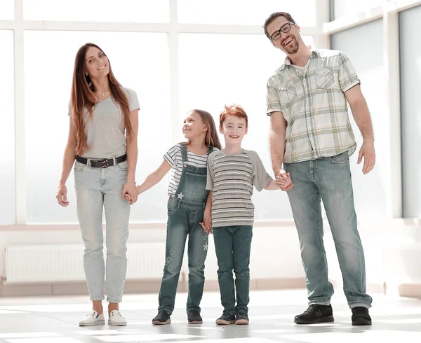 Lyckliga föräldrar med barn som står i en ny lägenhet — Stockfoto