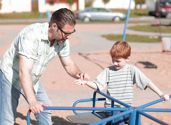 Unga far och Lille son på lekplatsen — Stockfoto