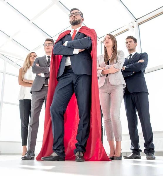 Líder en la capa roja y el equipo de negocios de pie juntos — Foto de Stock