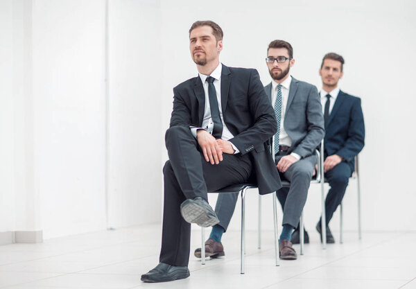 group of serious business people waiting for their turn