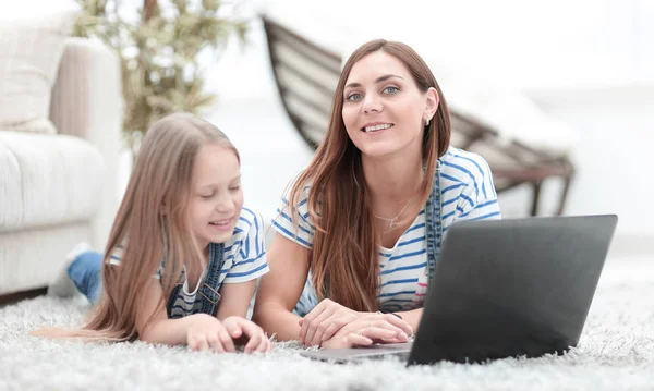 Anya és vele a kis lányom használ egy laptop, a szabadidőben — Stock Fotó