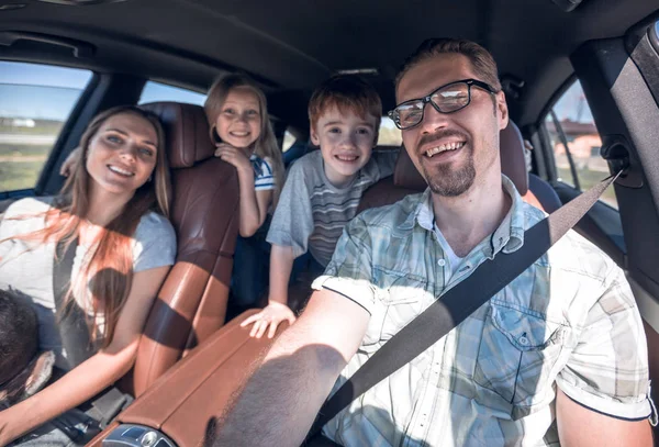 Família alegre com duas crianças vai para o carro — Fotografia de Stock