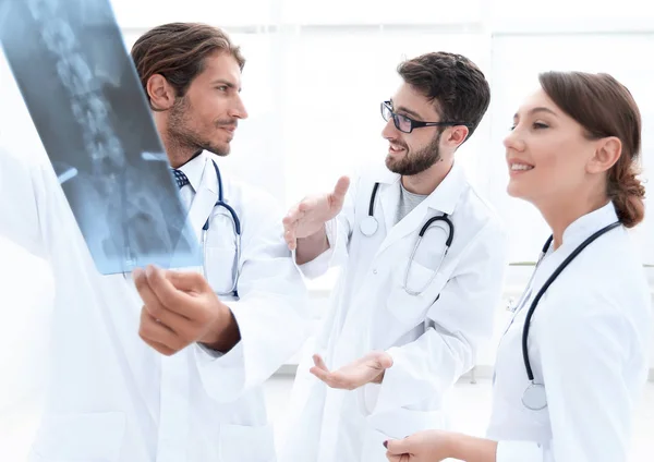 Три впевнені лікарі досліджують рентгенівський знімок — стокове фото