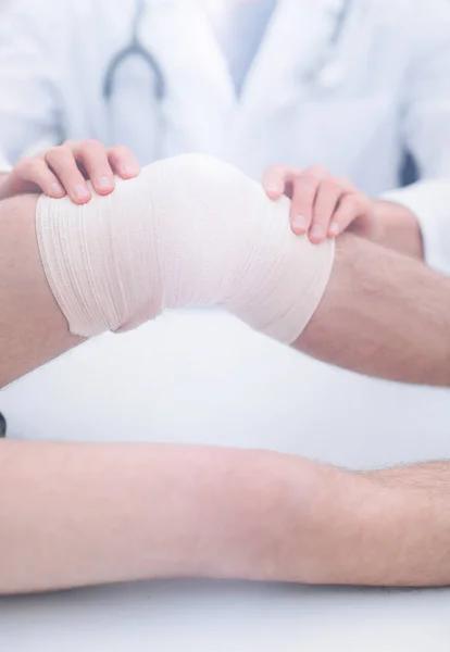 Traumatologista, aplicando uma bandagem no joelho — Fotografia de Stock