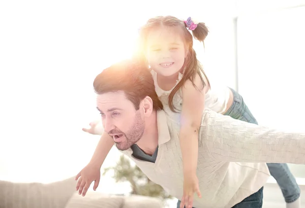 Pai feliz brincando com a filha na sala de estar brilhante — Fotografia de Stock