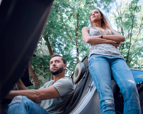 Young couple traveling by car makes a stop — Stock Photo, Image