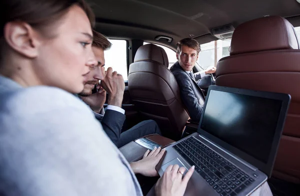 Team di lavoro utilizza un computer portatile per lavorare in auto — Foto Stock