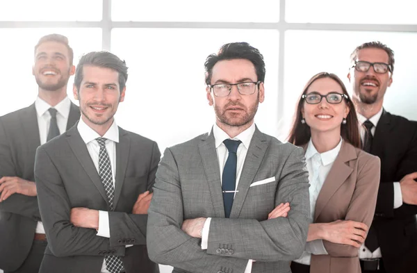 Happy business team med armar korsade på kontoret — Stockfoto