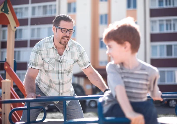 Lycklig far leker med liten pojke på lekplatsen — Stockfoto