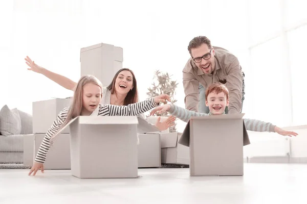 Família divertida usando as caixas para jogar no novo apartamento . — Fotografia de Stock