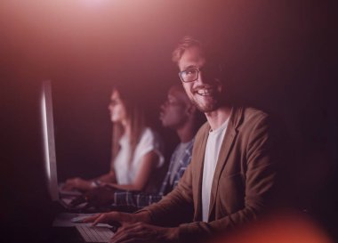 Geceleri ofiste çalışan gülümseyen