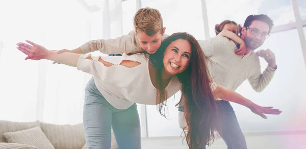 Glückliche Eltern spielen mit ihren Kindern im geräumigen Wohnzimmer — Stockfoto