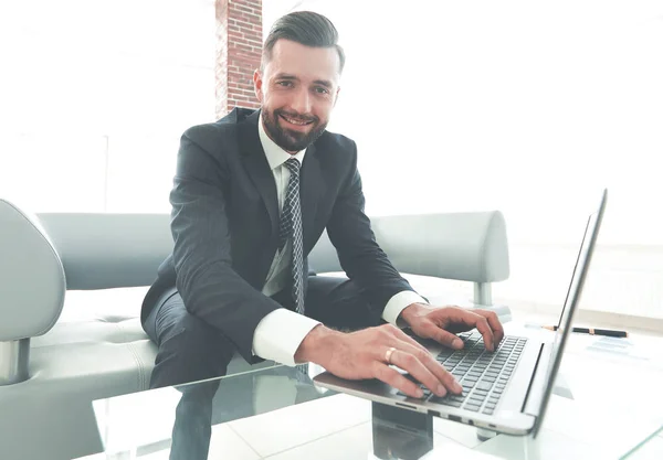 Homme qui travaille avec succès sur un ordinateur portable dans un bureau moderne — Photo