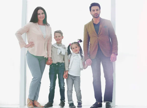 Portrait of a modern family standing near a large window — Stock Photo, Image