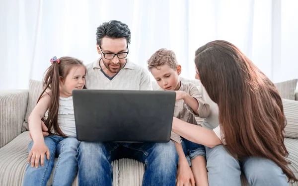 Familia moderna mirando a la pantalla del ordenador portátil . — Foto de Stock