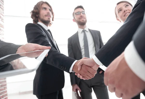 Anställda ser på de handshake affärspartnerna — Stockfoto