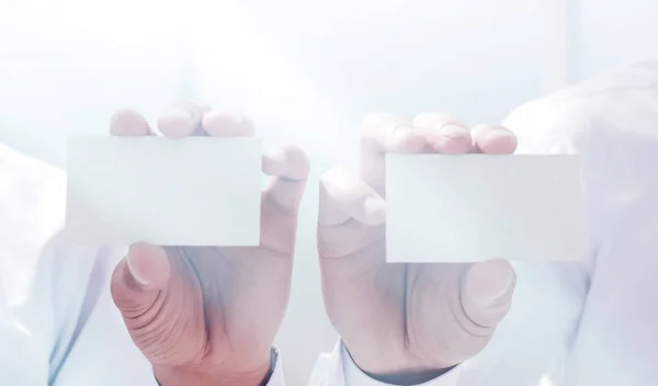 Close up. Two businessmen showing their business cards — стоковое фото