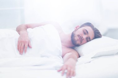 yakışıklı adam yeni yatak odasında yatmak.