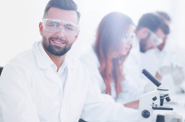 mikrobiyolog ve meslektaşları modern bir laboratuarda oturuyor