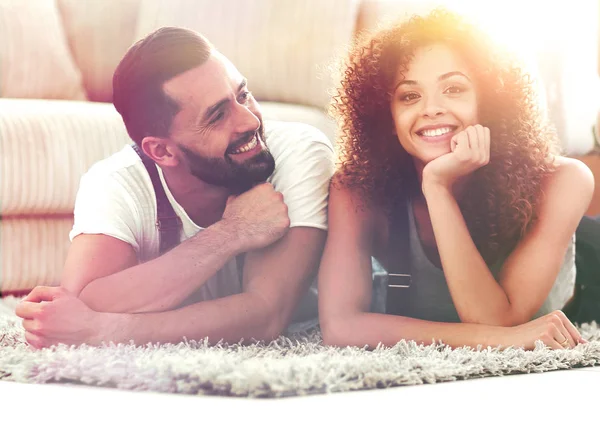 Concept of moving to a new home. Happy couple lying on the floor — Stock Photo, Image