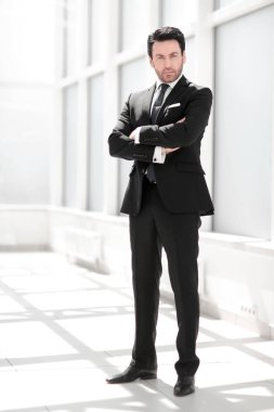 tam büyüme. parlak bir ofiste ayakta işadamı