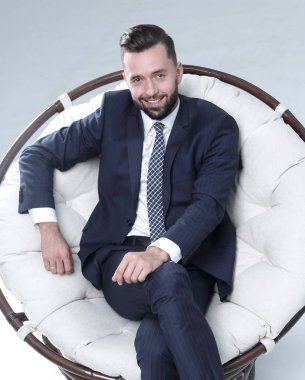 İş adamı rahat bir sandalyede oturuyor.