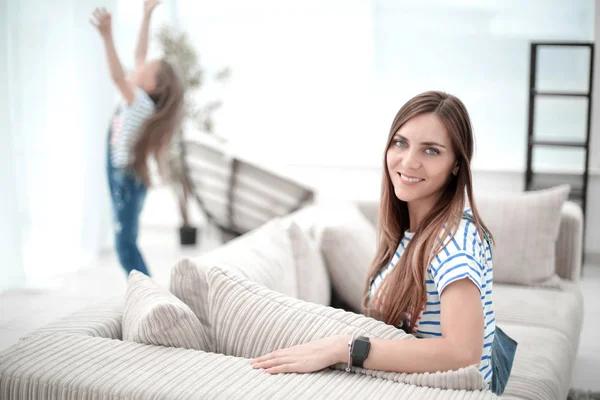 Mujer joven sentada en el sofá en la nueva sala de estar — Foto de Stock