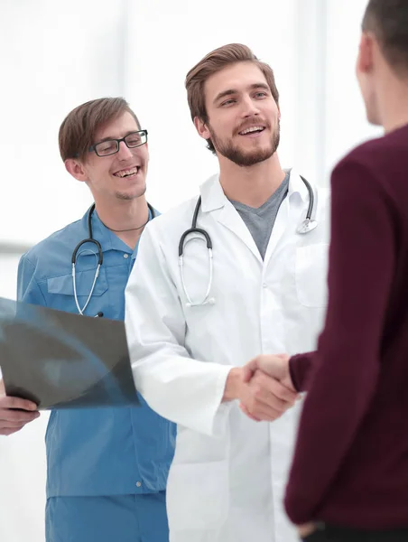 Medico sorridente stringendo la mano di un paziente — Foto Stock