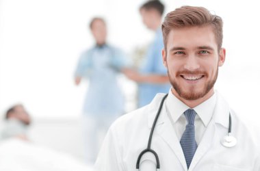 Doktor bulanık arka plan üzerinde gülümseyen