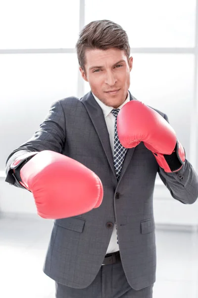 Бізнесмен в боксерських рукавичках, стоячи біля вікна офісу — стокове фото