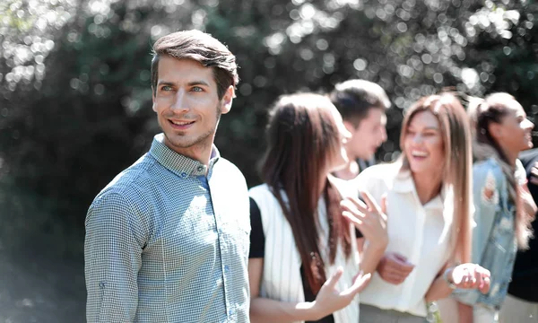 Moderner Kerl auf dem Hintergrund seiner Freunde. — Stockfoto