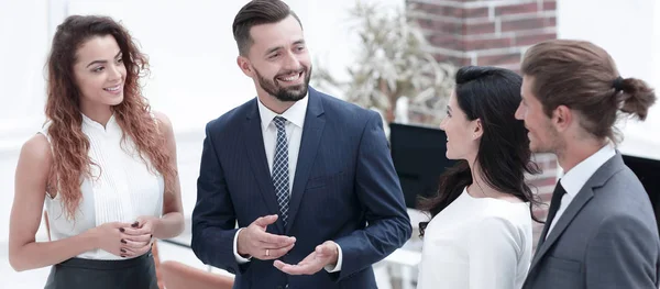 Glimlachende business team praten, staande in het kantoor — Stockfoto