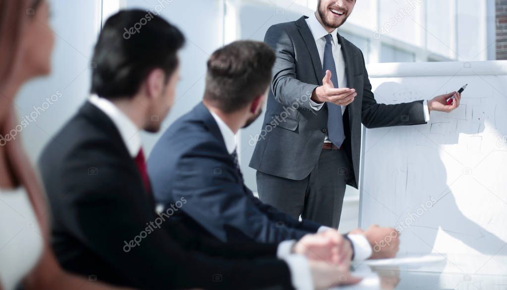 smiling businessman asks a question to colleagues at a business presentation