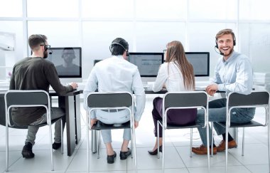 Geri bakış. Çağrı merkezinde oturan iş merkezinin çalışanları.