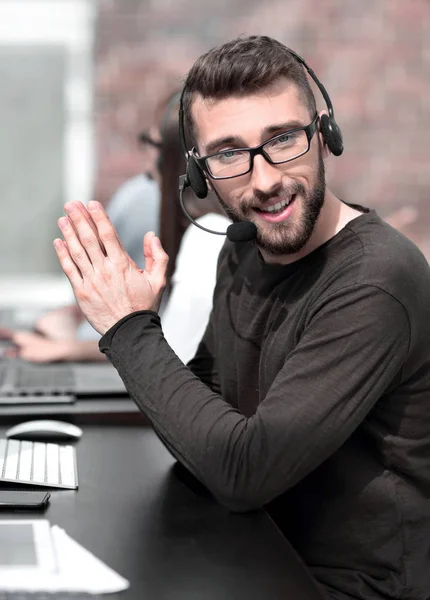 Close up.modern man in a headset sitting at his Desk — Stock Photo, Image